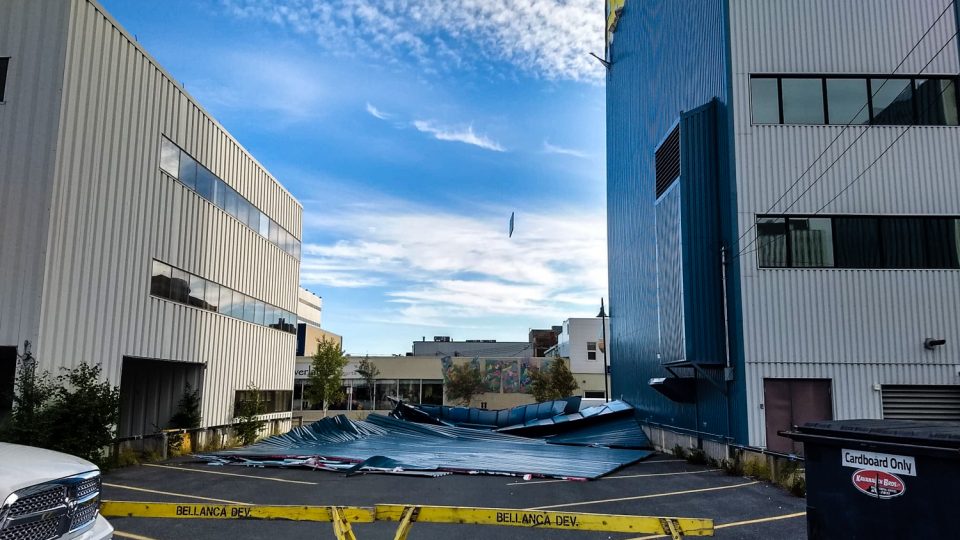 Siding lies crumpled at the foot of Yellowknife's Bellanca building
