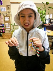 A student poses with jewellery created to help fund a water pump through UNICEF