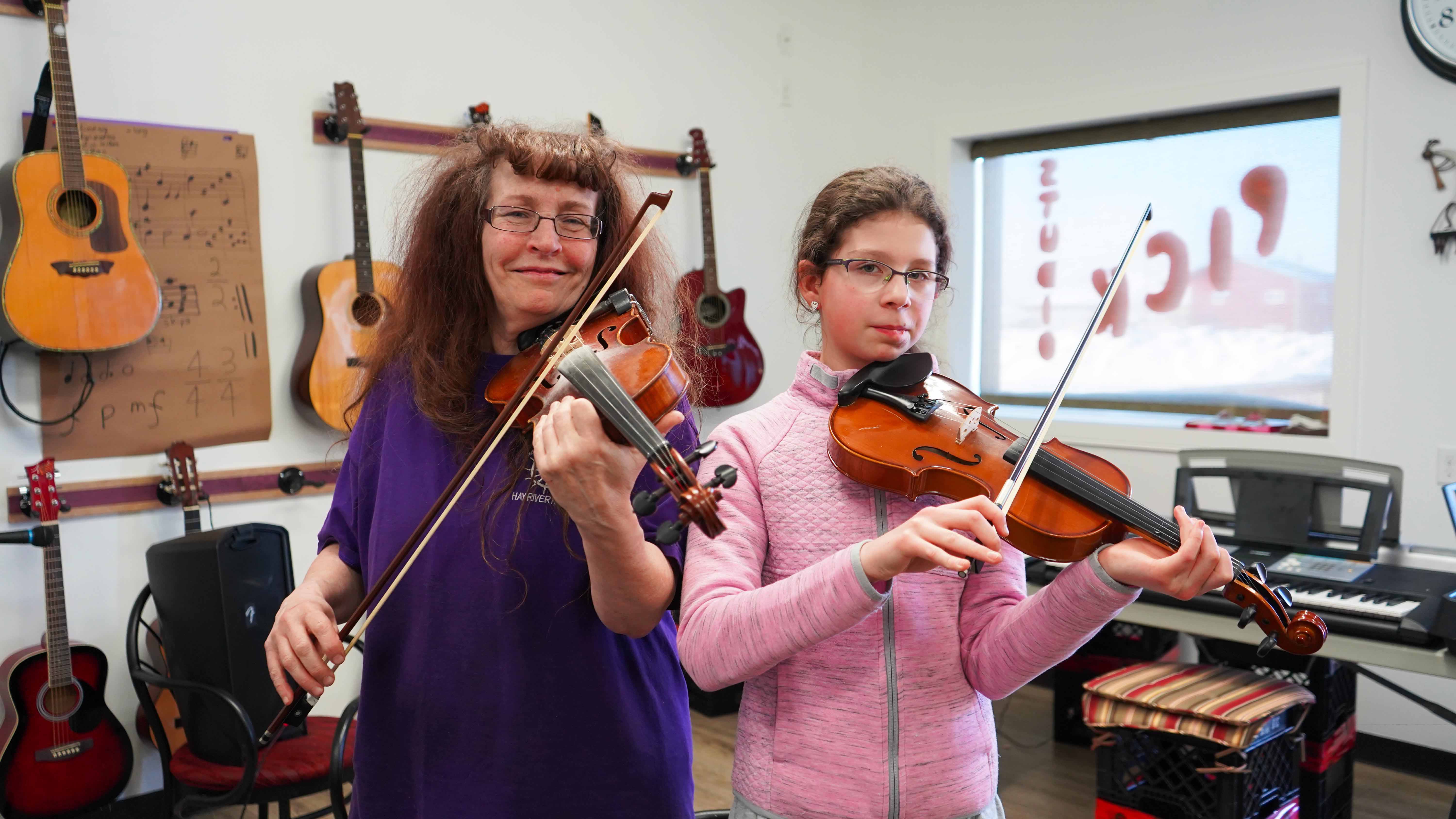 Linda Duford teaches Iga Olesinska the fiddle at the Purple Pick Studio. Sarah Pruys/Cabin Radio