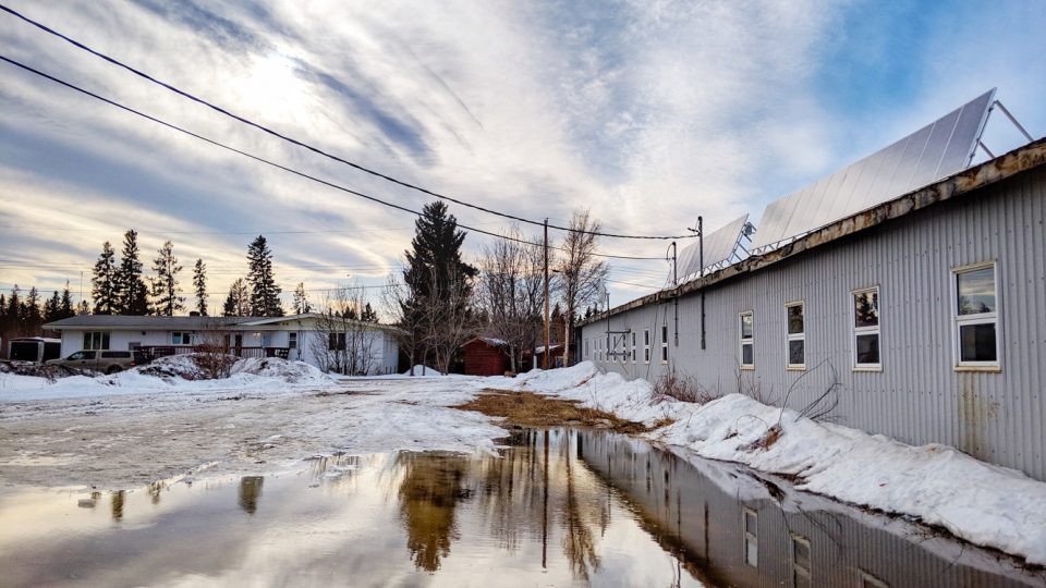 Sunlight hits a pool of melted snow and solar panels atop the Liidlii Kue First Nation's office in Fort Simpson on March 19, 2019