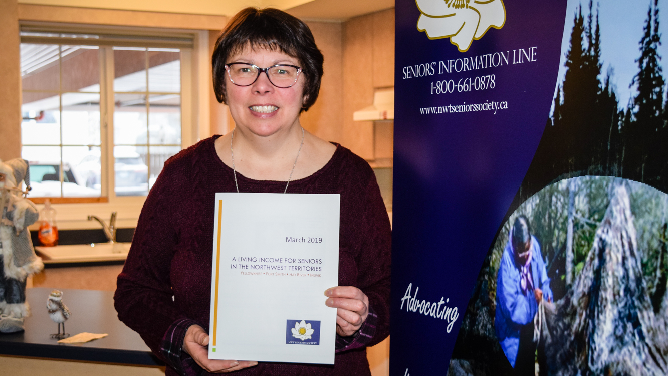 Suzette Montreuil, executive director of the NWT Seniors' Society, with a copy of the society's report studying living income for seniors