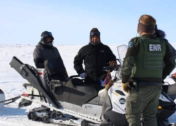 Yellowknives Dene hunters speak with an ENR wildlife officer