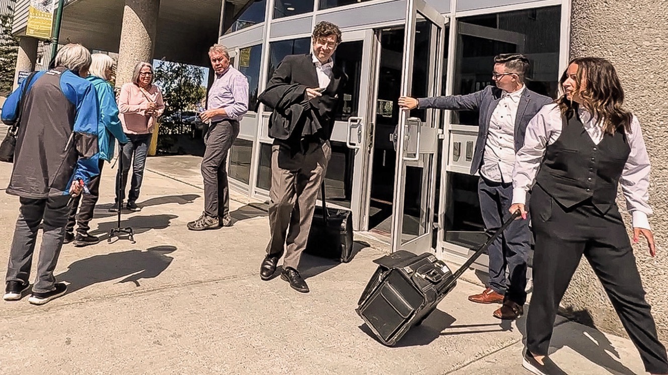 Duane Praught, lead Crown prosecutor in the Levi Cayen trial, exits the Yellowknife Courthouse on Wednesday with the family of Alexander Norwegian to the left