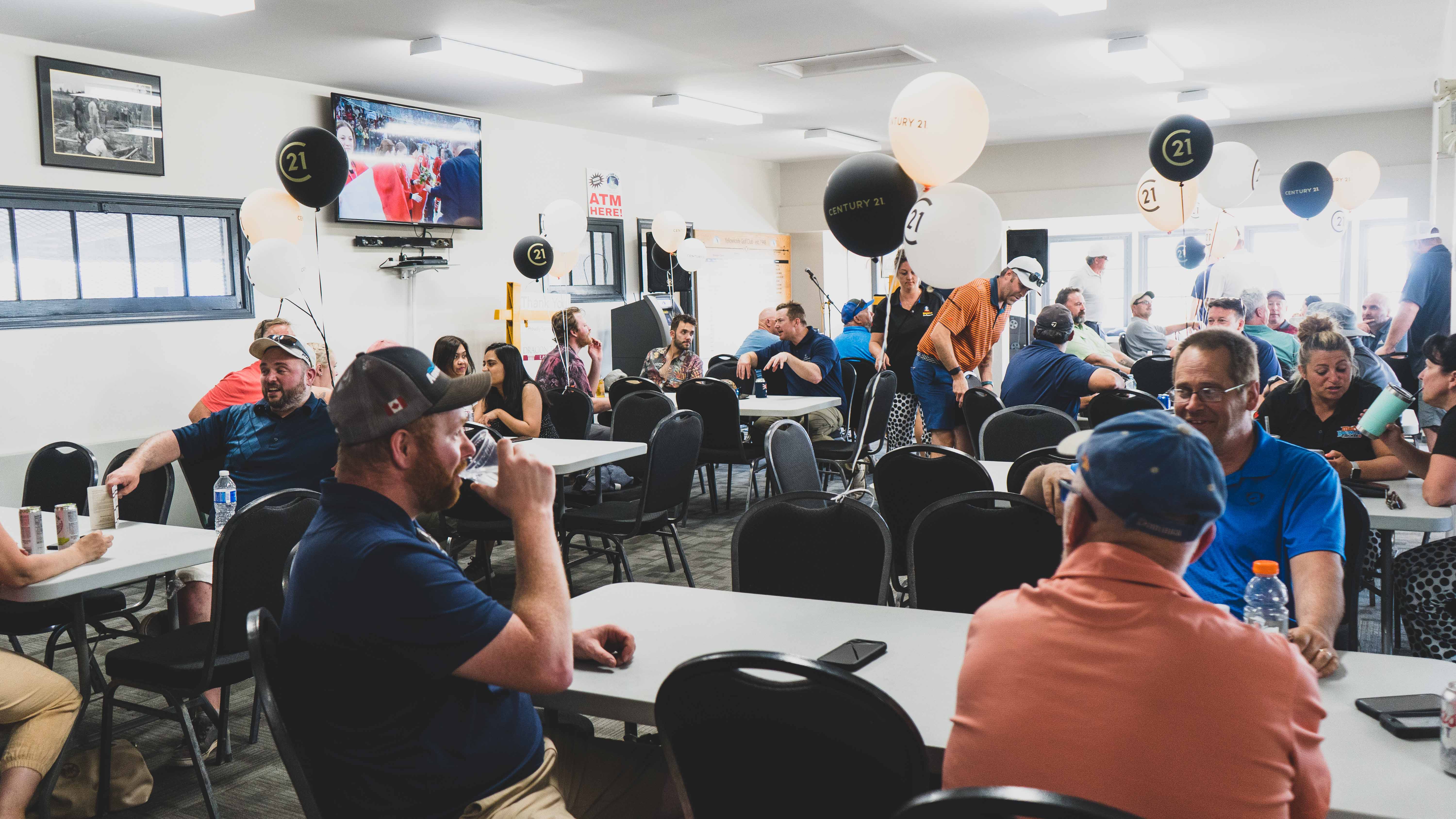 Golfers relax in the clubhouse and check out the silent auction items before dinner starts. Sarah Pruys/Cabin Radio