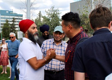 Jagmeet SIngh, left, meets Yellowknife residents at the city's farmers' market on July 19, 2022