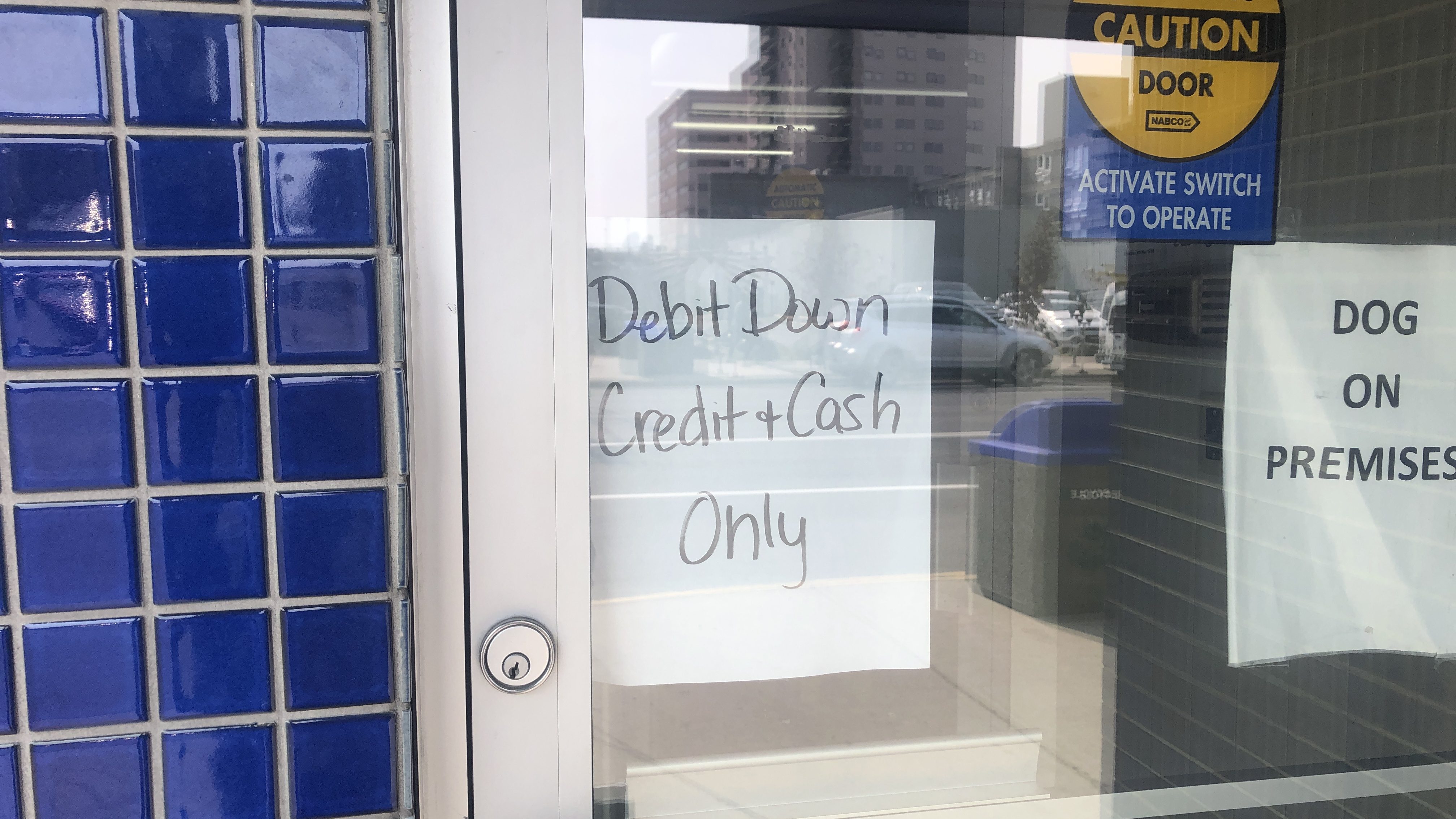 A sign outside Sutherland's Drugs in Yellowknife warning customers Interac Debit is down. Caitrin Pilkington/Cabin Radio