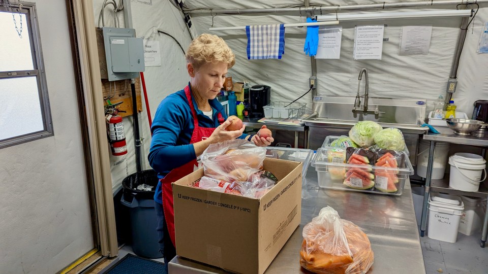 Volunteer Gail Nesbitt prepares produce for distribution