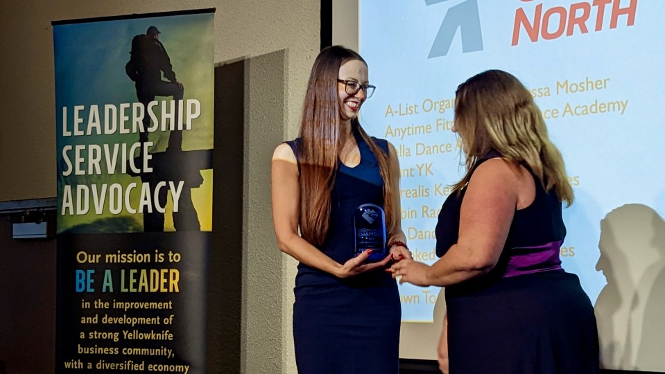 Phoenix Smith, left, receives the 2022 small business of the year award from Canadian North's Samantha Stuart