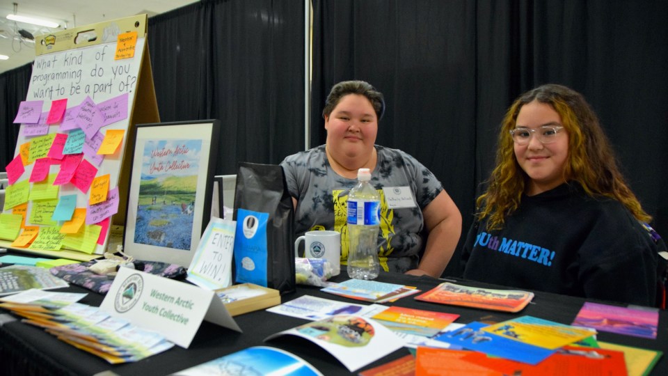 Sisters Nathalie and Aubrey Bullock help run the booth for the Western Arctic Youth Collective