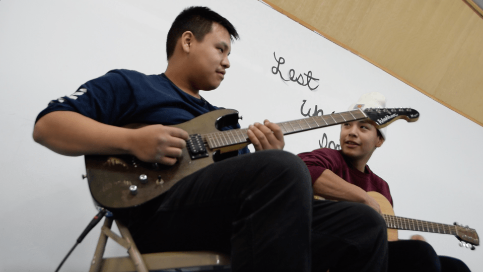 Nathan Kuptana and Chase Nogasak playing guitar during House of Hope hours at Kitti Hall