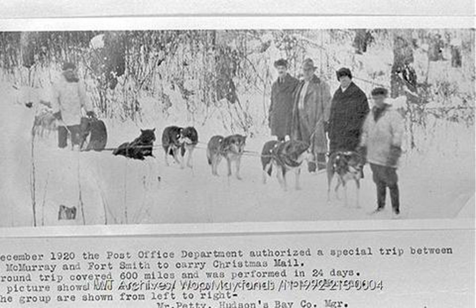 In December 1920, the Post Office Department authorized a special trip between Fort McMurray and Fort Smith to carry Christmas mail. The round trip covered 600 miles and was performed in 24 days. This picture shows the dog train ready to depart from Fort McMurray