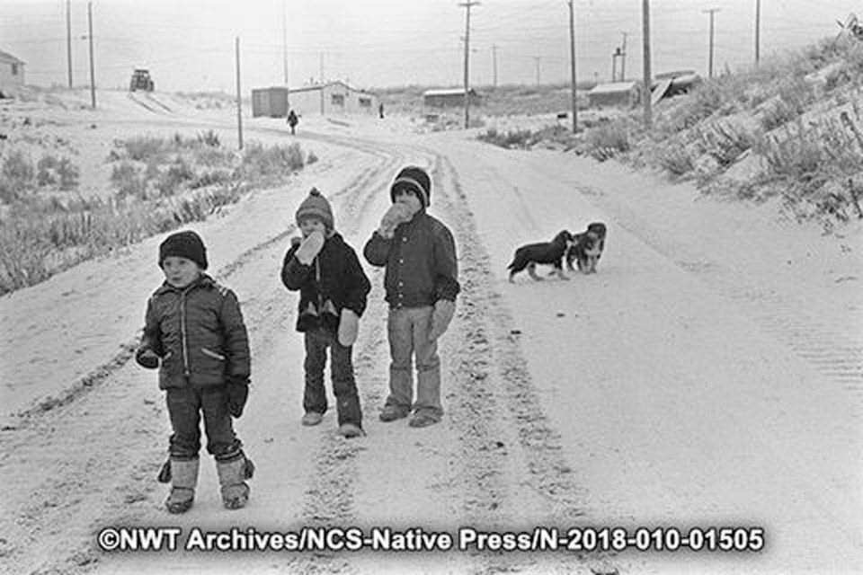 Children and puppies in Tsiigehtchic in December 1973
