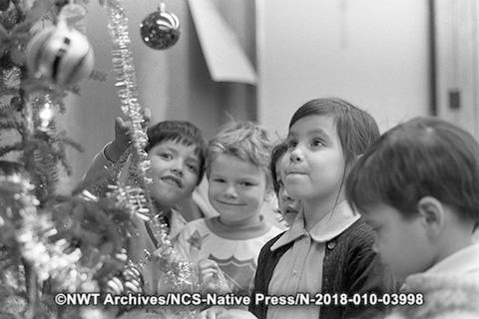 A Tessa Macintosh photo shows Tree of Peace kindergarten students standing beside a Christmas tree
