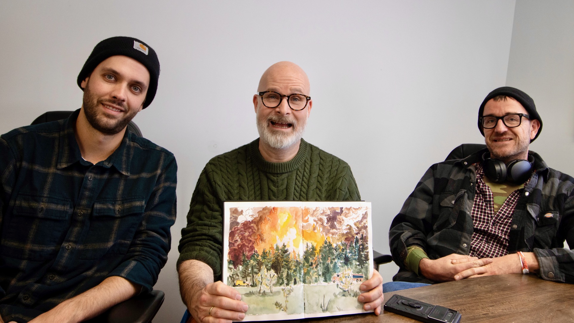 Dominik Heilig (centre) displays an illustration of the Scotty Creek fire with researchers Kyle Arndt (left) and Oliver Sonnentag. Megan Miskiman/Cabin Radio