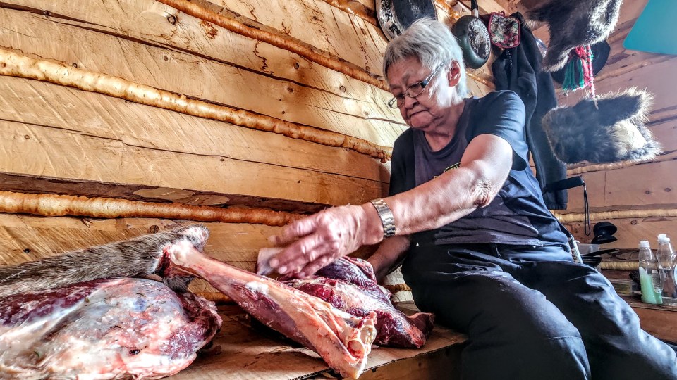 Alice Vittrekwa prepares caribou meat