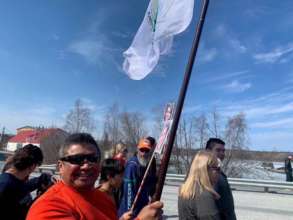 Wilbert Cook held a Yellowknives Dene First Nation flag as the marchers neared Ndilǫ