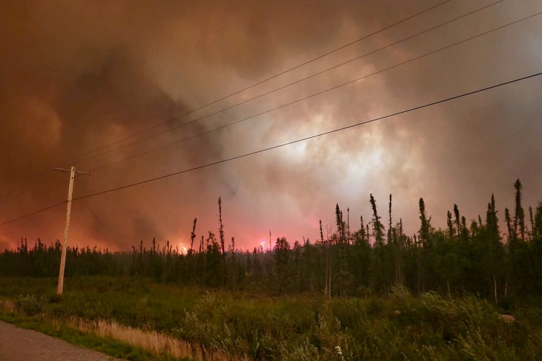 A photo by Teresa Zoe shows a wildfire near Behchokǫ̀ on July 25, 2023.