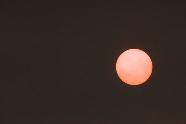 The sun behind a veil of smoke over Yellowknife on August 7, 2023. Sarah Pruys/Cabin Radio