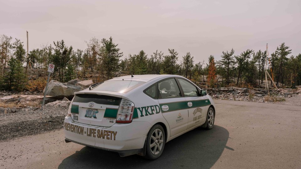 A City of Yellowknife fire division vehicle near a line of sprinklers in Grace Lake. Sarah Pruys/Cabin Radio
