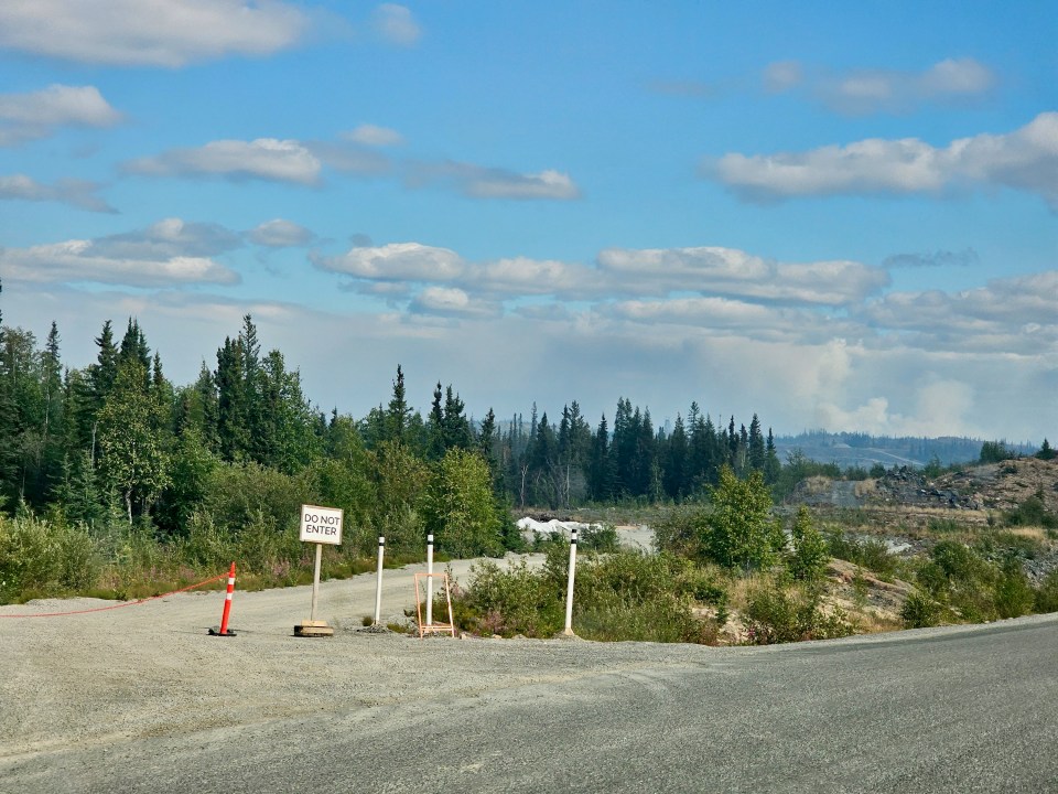 Fire ZF011's plume is visible, on the right, from the Ingraham Trail on August 7, 2023. Ollie Williams/Cabin Radio