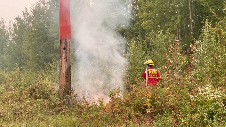 A Hay River Fire Department crew members attends to a hotspot. Photo: GNWT