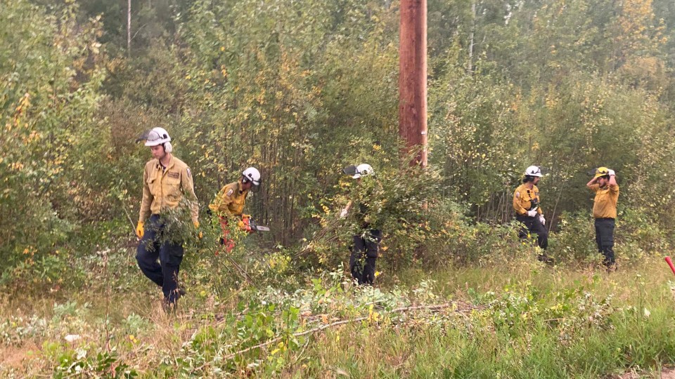 Firefighters clear brush to prevent a wildfire from spreading. Photo: GNWT