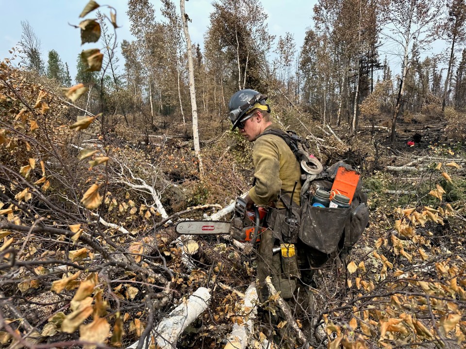 A fire crew member at work on measures designed to hold back fire ZF015 on August 3, 2023. Photo: GNWT