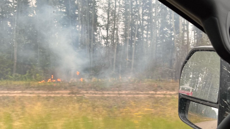 Flames scould be seen from the road while driving out of Yellowknife on August 16, 2023. Photo: Maria Leppanen