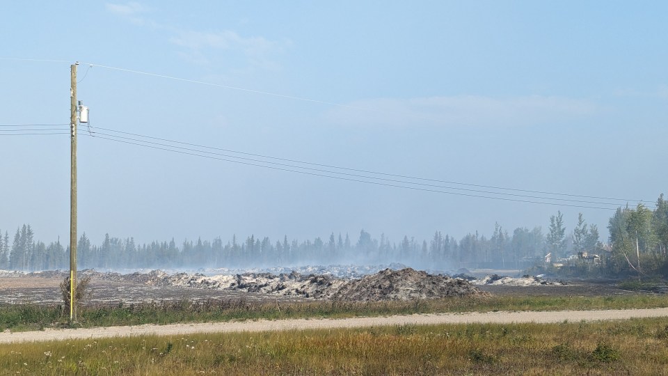 A fire break smoulders on the south end of Enterprise on August 16, 2023. Sarah Pruys/Cabin Radio