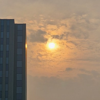 The sun, shrouded in smoke, is seen behind Yellowknife's Northwestel Building on September 22, 2023. Ollie Williams/Cabin Radio