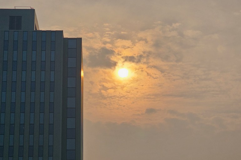 The sun, shrouded in smoke, is seen behind Yellowknife's Northwestel Building on September 22, 2023. Ollie Williams/Cabin Radio