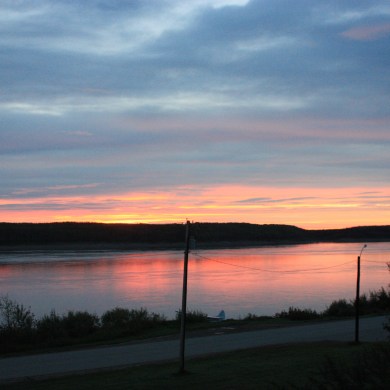 The sun rises over the Mackenzie River in Fort Simpson on September 1, 2023. Emily Blake/Cabin Radio