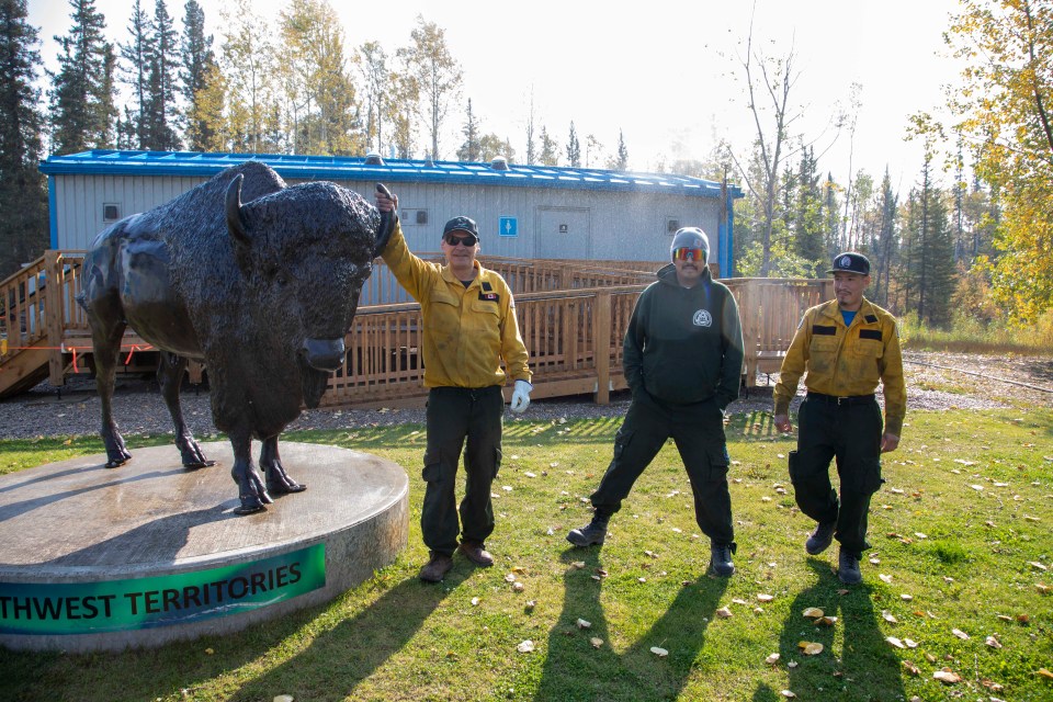 Hay River fire crew SS6 makes a daily stop at the NWT-Alberta Border welcome station on the morning of September 15 to start a network of sprinklers set up to protect the camp from nearby wildfires. From left: Clarence Tonga of Fort Providence and Nathan Fabian and Ton Farcy, both of Hay River, tended pumps at a number of sites-at-risk since fires raged over the region from mid-August. Photo: Bill Braden