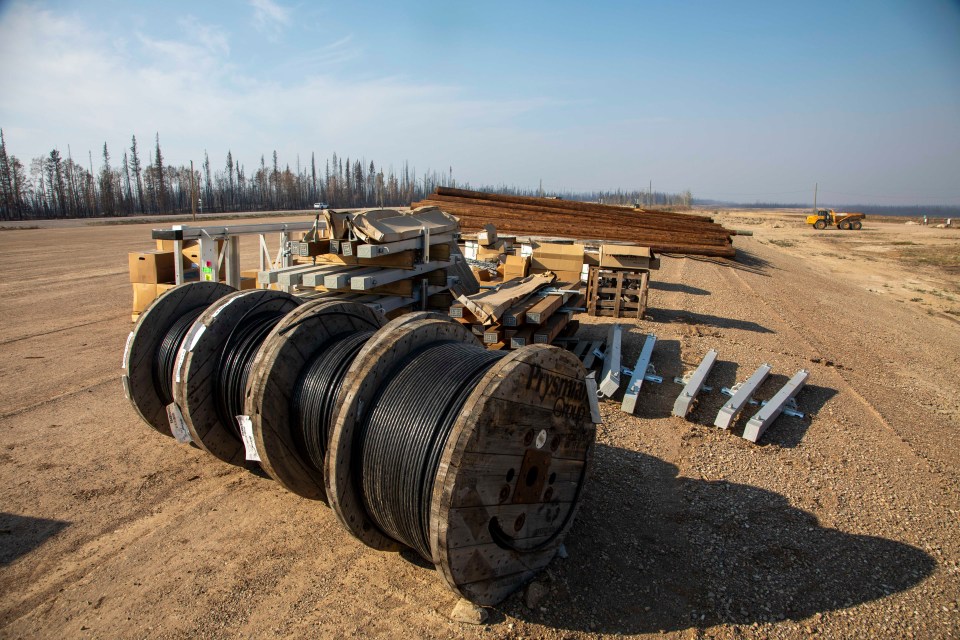 Power comes back to Enterprise: big spools of new cable and boxes of power line fittings share a loading site with dozens of wooden power poles to replace those lost. Photo: Bill Braden