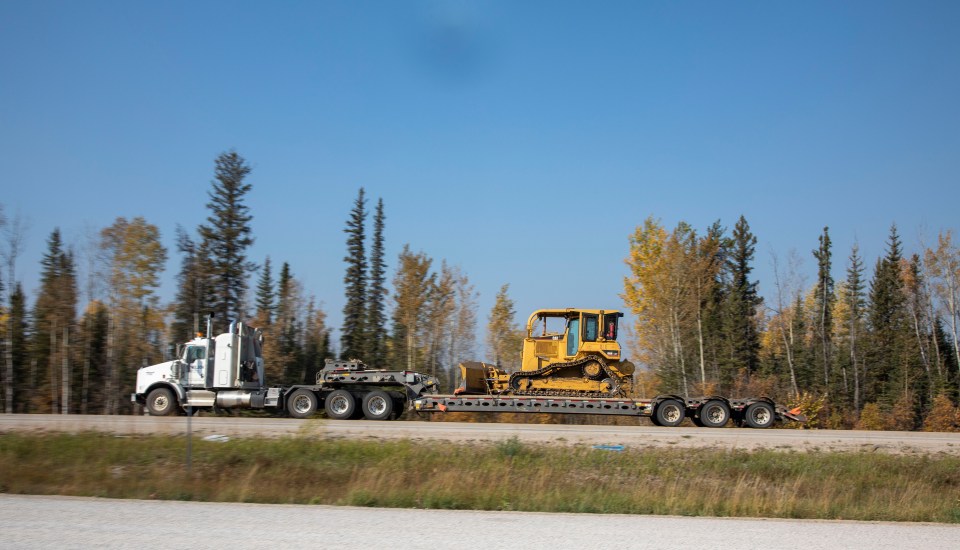 On Highway 1 near Virginia Falls, a southbound truck transports one of dozens of pieces of heavy equipment that were employed to build fire breaks. Photo: Bill Braden
