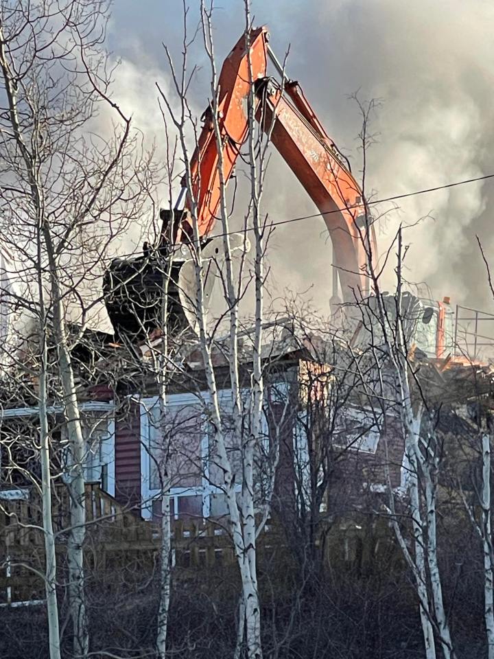 Heavy equipment appeared to tear down parts of the building to stop the fire spreading. Photo: Tracey Foster DeBaie