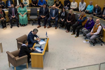 RJ Simpson signs documents with NWT Commissioner Margaret Thom at the swearing-in ceremony for MLAs of the 20th Assembly. Ollie Williams/Cabin Radio