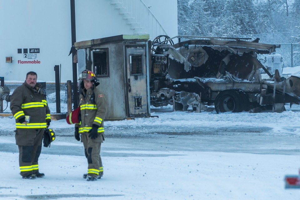 Firefighters in front of the remains of a truck that burned in Yellowknife on December 22, 2023. Ollie Williams/Cabin Radio