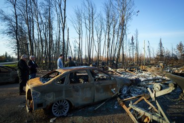 Prime Minister Justin Trudeau speaks with Chaal Cadieux, right, on his wildfire-hit Enterprise lot in October 2023. Adam Scotti/PMO