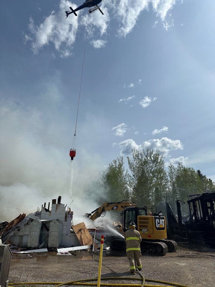 A helicopter assists with efforts to put out a house fire in Fort Resolution. Photo: Louis Balsillie