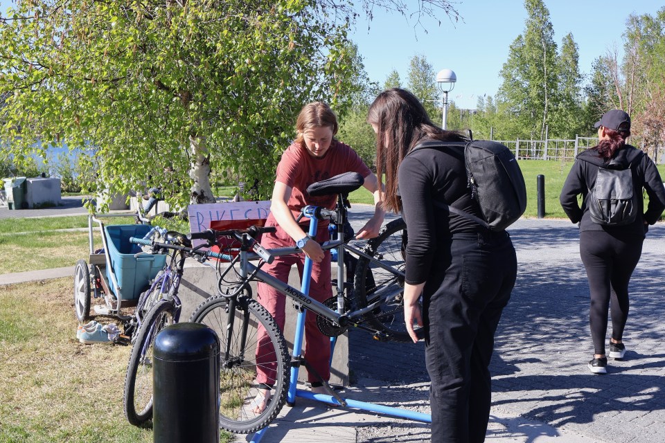 Jennings helps repair a bike. Caelan Beard/Cabin Radio