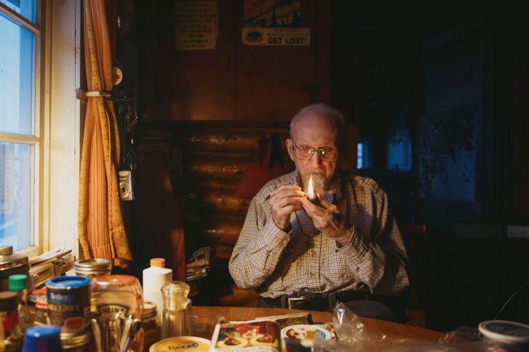 Bern Will Brown lights a pipe at his home in Colville Lake, Northwest Territories. Photo: Pat Kane