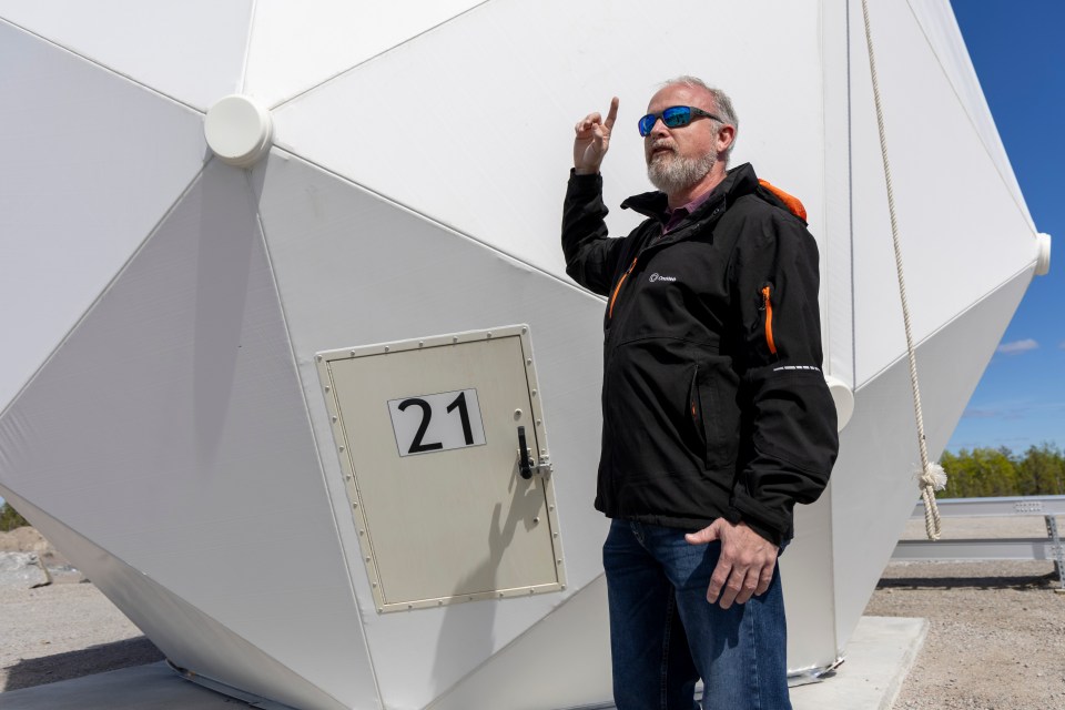 Eutelsat OneWeb's Harley McDonald shows an antenna dome to visitors during the inauguration of a satellite network portal in Yellowknife. Ollie Williams/Cabin Radio