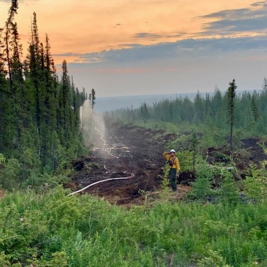 A firefighter working on fire VQ001 is seen in a photo published by NWT Fire on June 29, 2024.