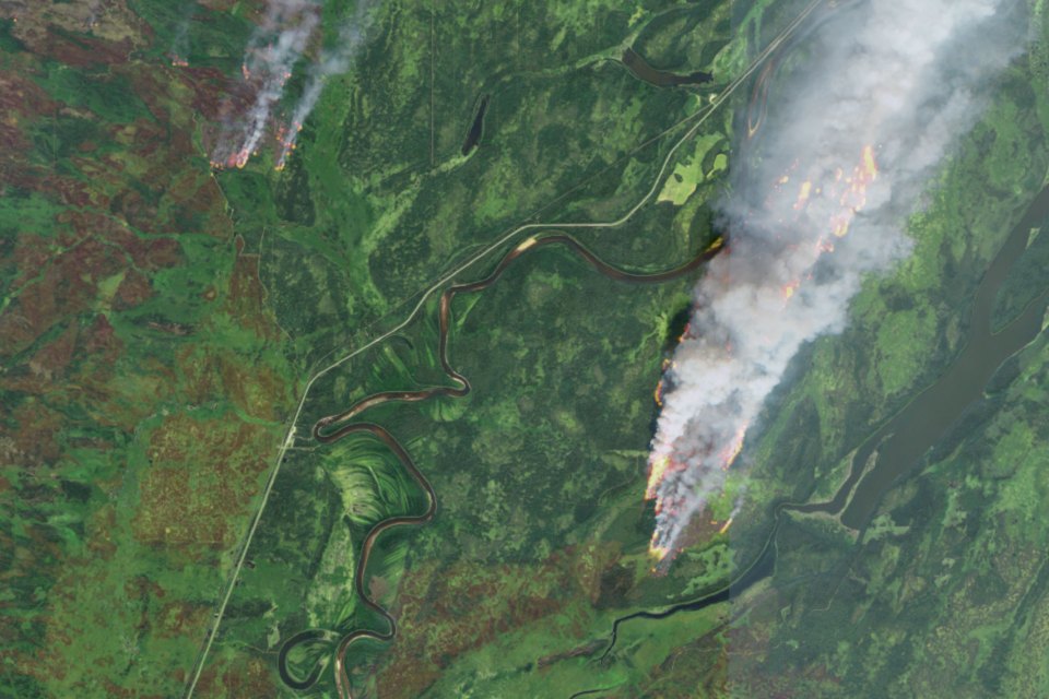 Wildfires either side of the highway at the NWT-Alberta border on August 12, 2024 are seen in a composite Sentinel-2 image blending smoke and hotspots.
