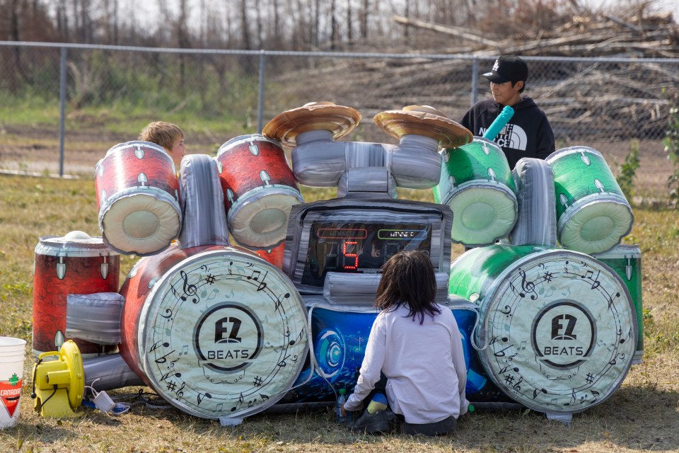 Two contenders share a moment while playing a giant drum kit at the Enterprise Gateway Jamboree. Ollie Williams/Cabin Radio