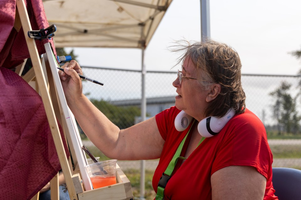 Genevieve Clarke painting at the Enterprise Gateway Jamboree. Ollie Williams/Cabin Radio