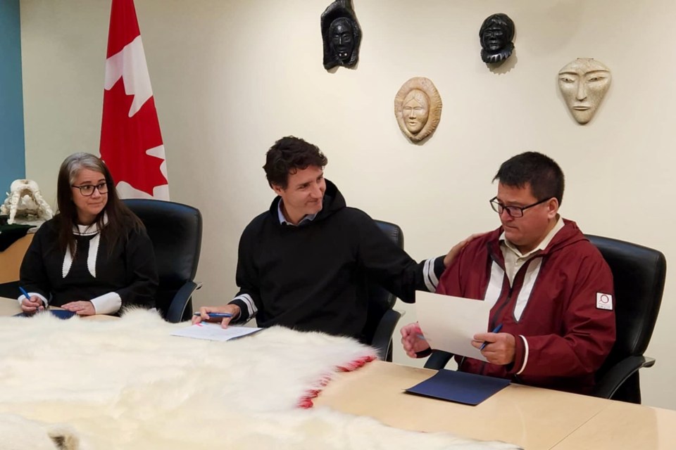 From left: Semmler, Trudeau and Smith sign the agreement. Karli Zschogner for Cabin Radio