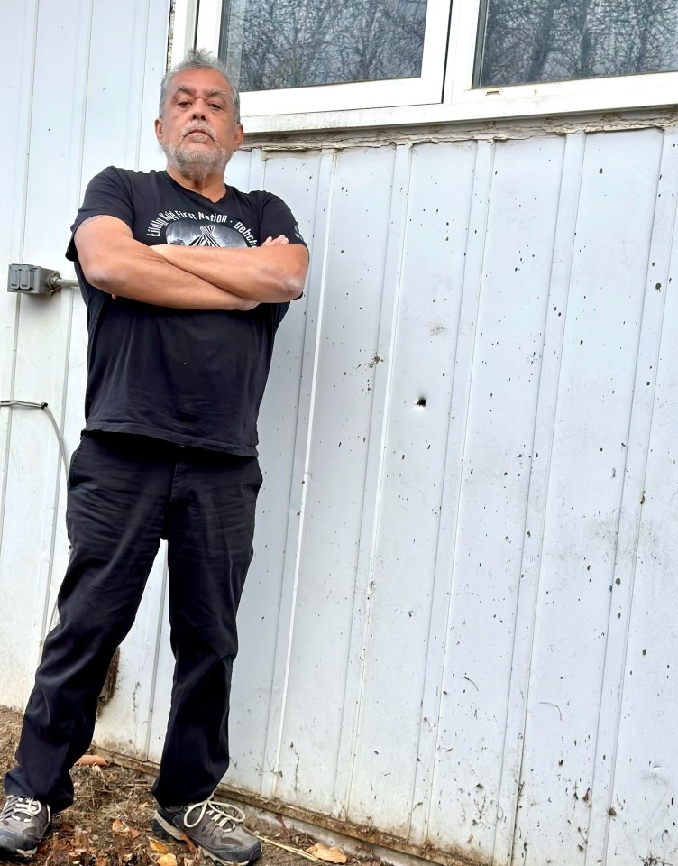 Dennis Nelner stands beside a hole left by a bullet that went through the wall of his house and hit his leg in 2019. Photo: Dennis Nelner