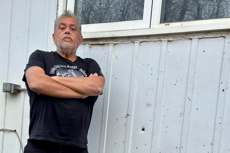 Dennis Nelner stands beside a hole left by a bullet that went through the wall of his house and hit his leg in 2019. Photo: Dennis Nelner